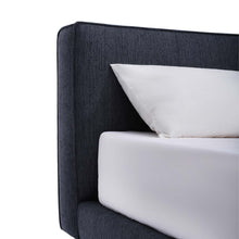 Load image into Gallery viewer, The Emery bedframe features a cushioned headboard, the flat surface can serve as a shelf for small items like phones, glasses and more. Additionally, the platform structure facilitates simple sheet-changing without having to lift the mattress - a feature your back is sure to appreciate. Choice of fabric available.