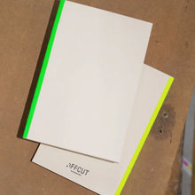 Load image into Gallery viewer, White card with green border on brown cardboard background

