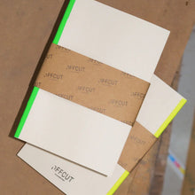 Load image into Gallery viewer, Cardboard sheets with 'OFFCUT' branding on a brown surface
