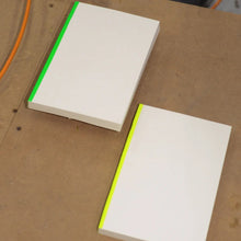 Load image into Gallery viewer, Two white books with green edges on a brown surface

