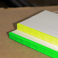 Load image into Gallery viewer, Stack of green and yellow notebooks on a brown surface
