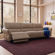 Beige sectional sofa in a living room with large windows and a purple rug.