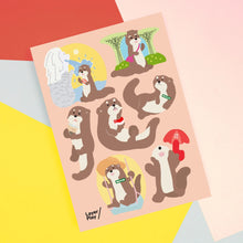 Load image into Gallery viewer, Sheet of cartoon otter stickers with various poses on a colorful background

